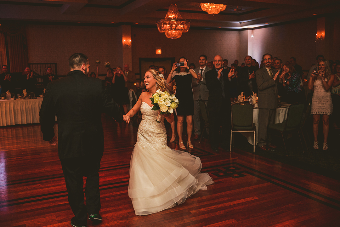 the bride laughing as her husband spins her on the dance floor