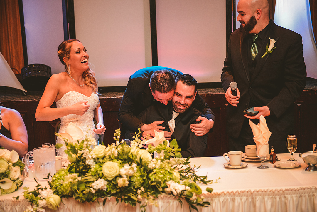 the best man hugging the groom after giving a speech