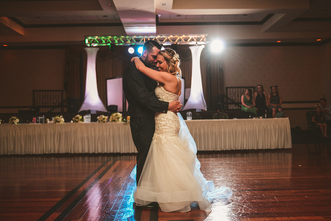 a wide photo of a bride and groom dancing on the dance floor at their reception