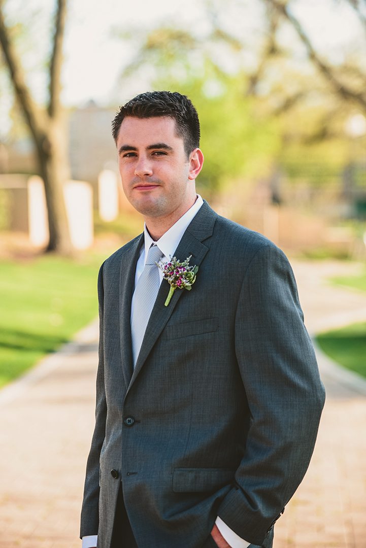 a serious groom standing in a Ralph Lauren suit at his Chicago elopement