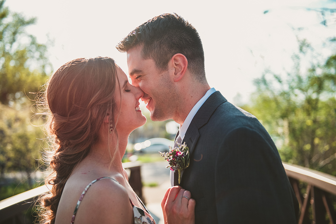 a man and a woman kissing with a sun flare in the background