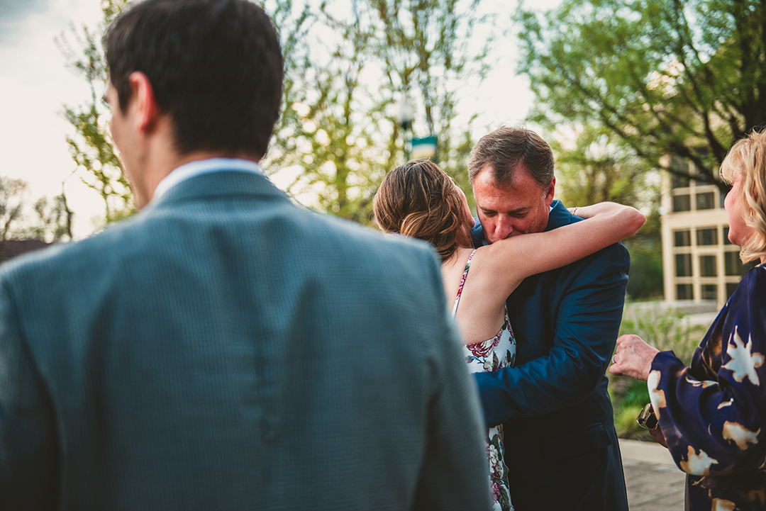 a man kissing a brides shoulder as he says hello at a outside wedding elopement