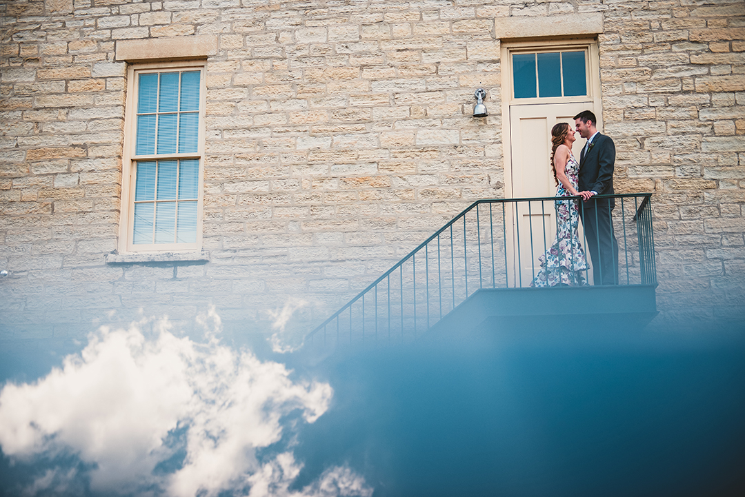 a creative cloud photo of a bride and groom kissing on stairs