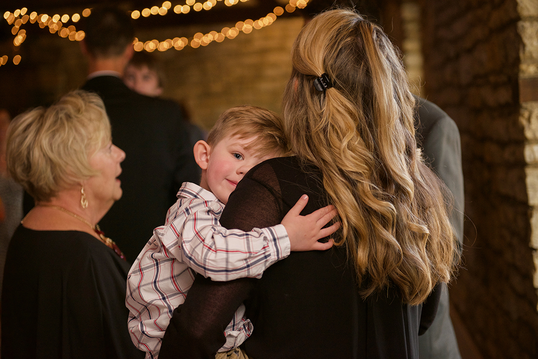 a young boy hugging his mom at a rustic Chicago wedding venue
