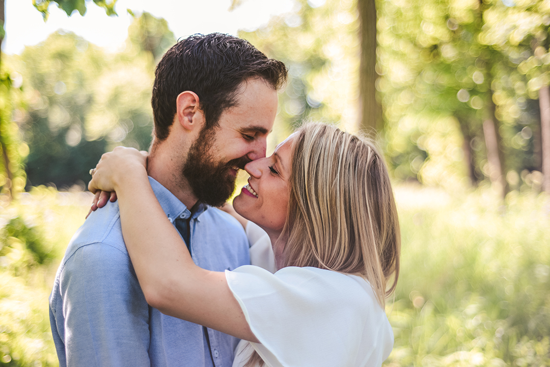 a man and a woman getting close for a kiss while smiling in Hammel Woods