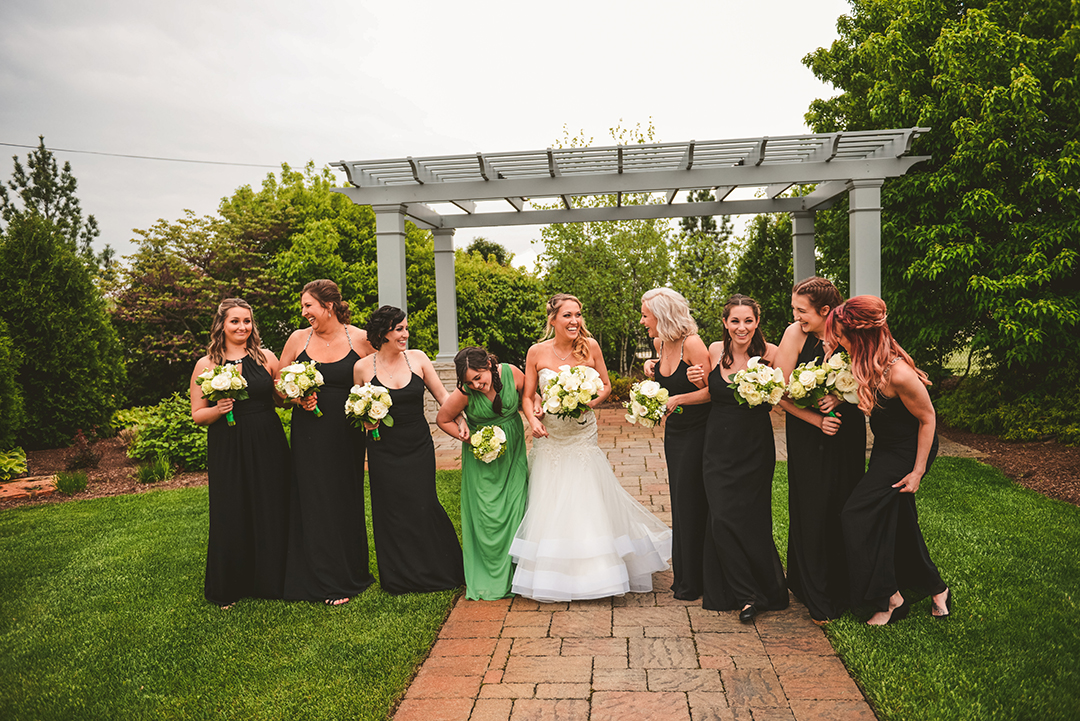 bridesmaids walking while laughing as the bride trips