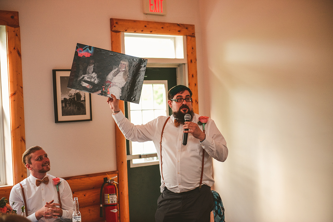 the best man holding up a poster he made for the bride and groom during his speech