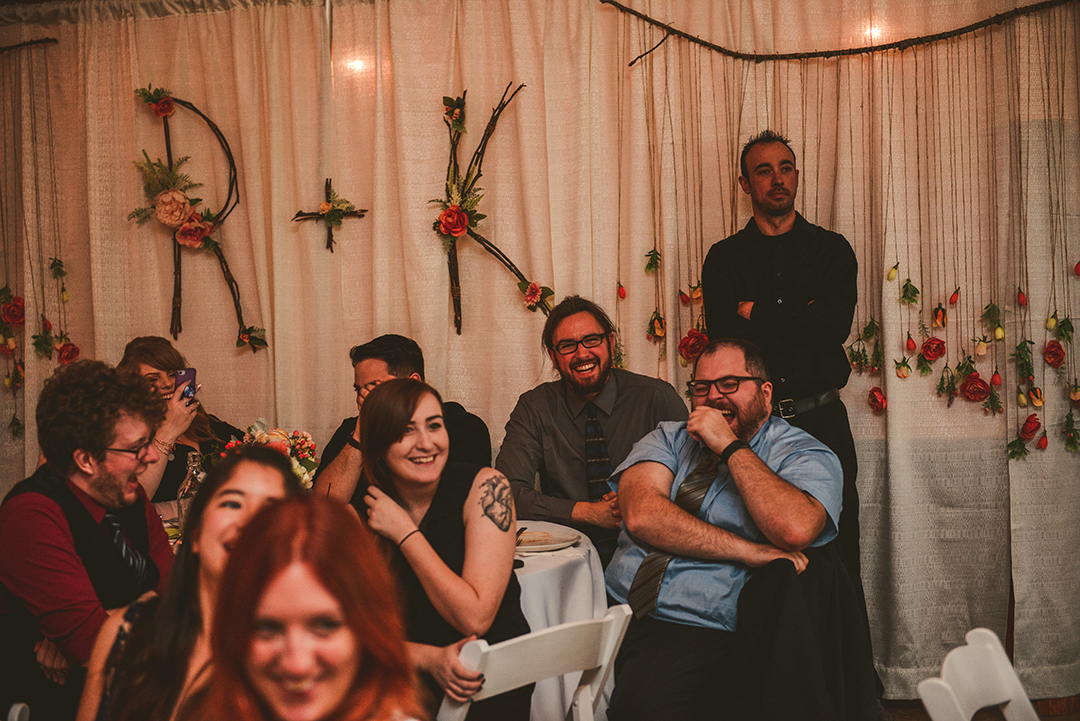 wedding guests laughing as the best man says his speech in a rustic barn in Woodstock IL