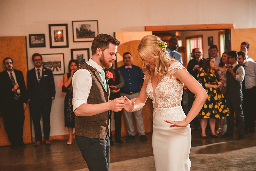 a bride and groom dancing during their first dance in Woodstock at an old barn