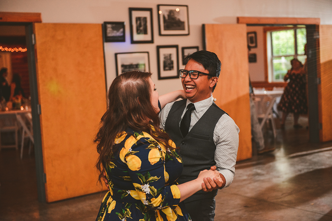 a man and a woman dancing as they laugh at a wedding reception in a barn in Woodstock IL