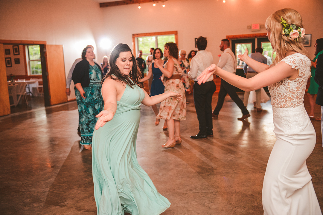 the maid of honor dancing with the bride in a light blue dress at a wedding reception in Woodstock IL