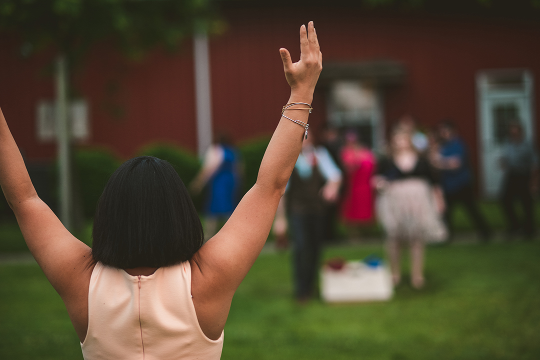 a woman throwing up her hands while playing bags at the All Season Orchard in Woodstock IL