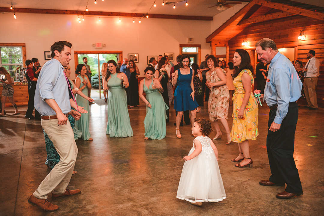 a bunch of wedding guests dancing with the flower girl at the All Season Orchard in Woodstock IL