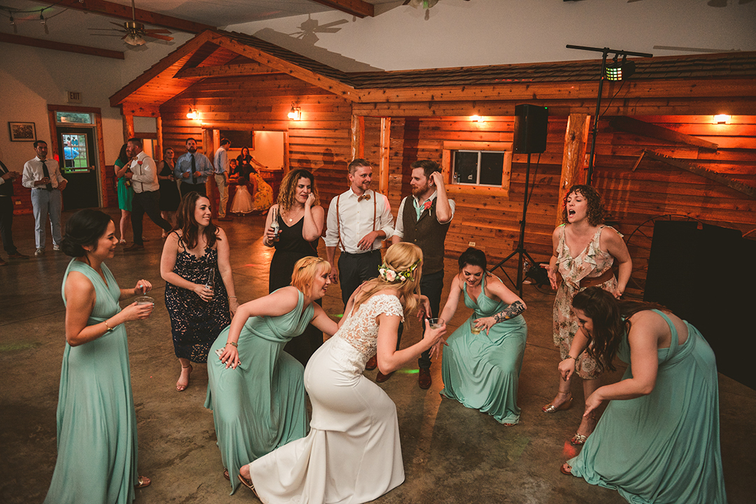 all of the bridesmaids dancing with the bride at the All Season Orchard in Woodstock IL in a rustic barn