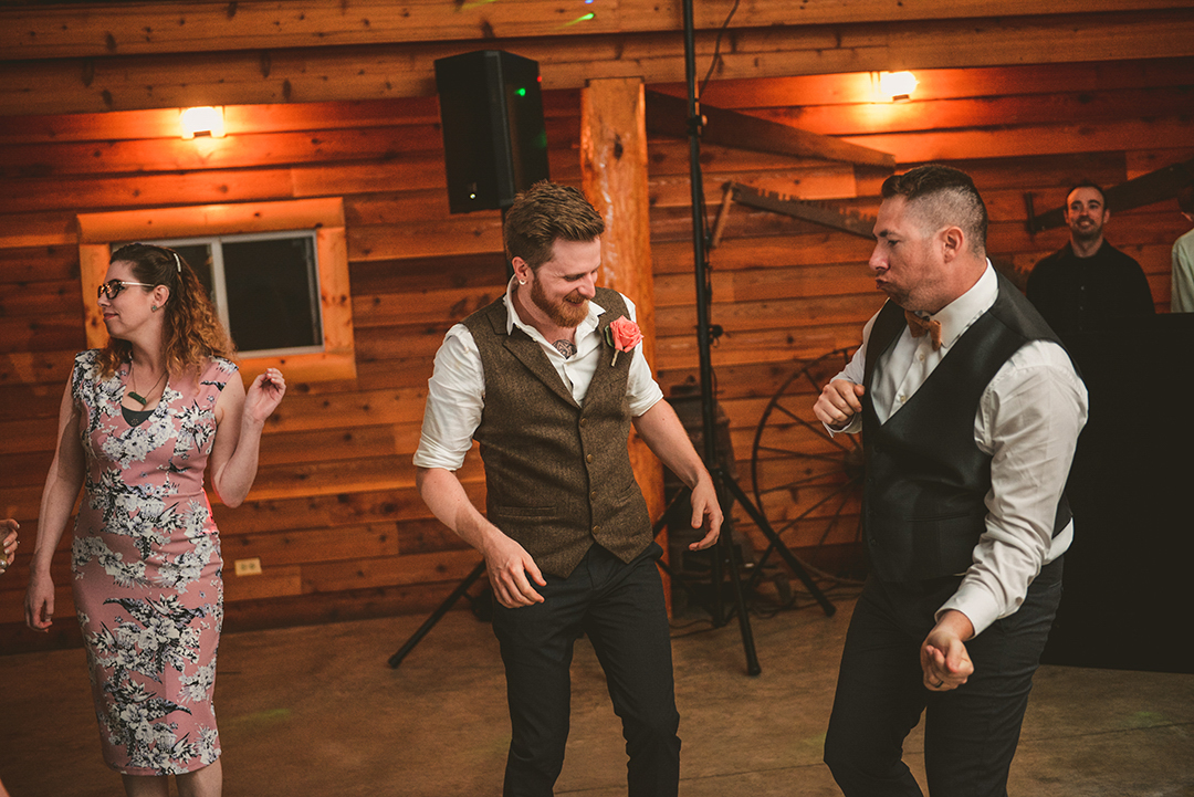 the groom dancing with his friend at the All Season Orchard in Woodstock