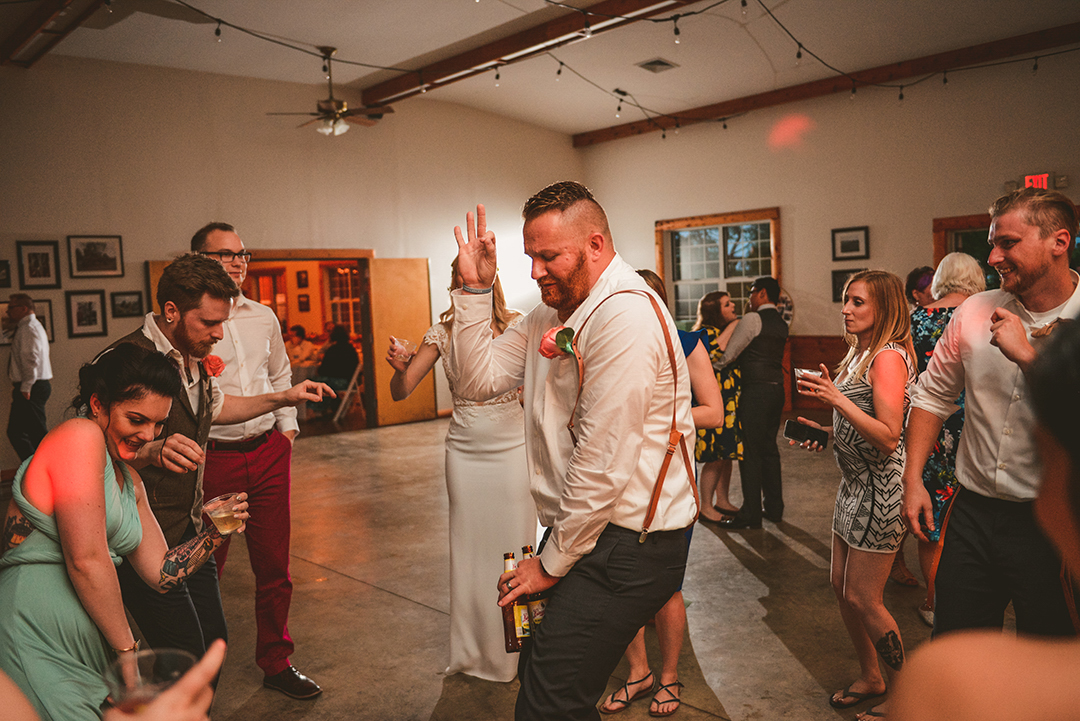 groomsman busting a move on the dance floor of All Season Orchard in Woodstock