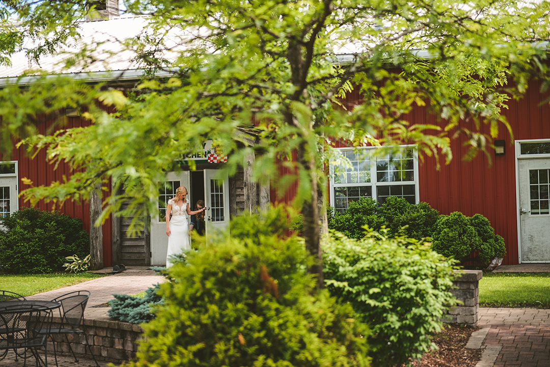 a bride walking out of a barn moments before her first look in Woodstock IL