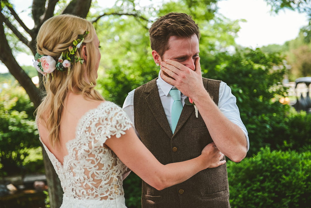 a groom crying as he sees his bride for the first time as she hugs him at the All Seasons Orchard in Woodstock