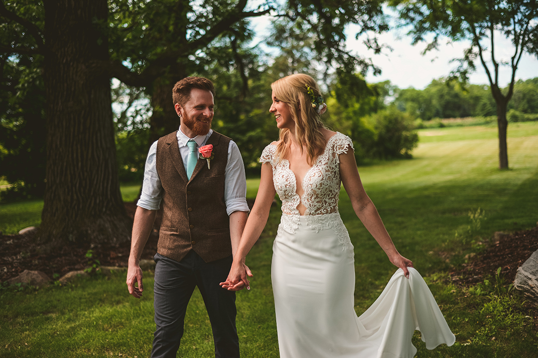 a husband and wife laughing as they walk in an orchard in Woodstock