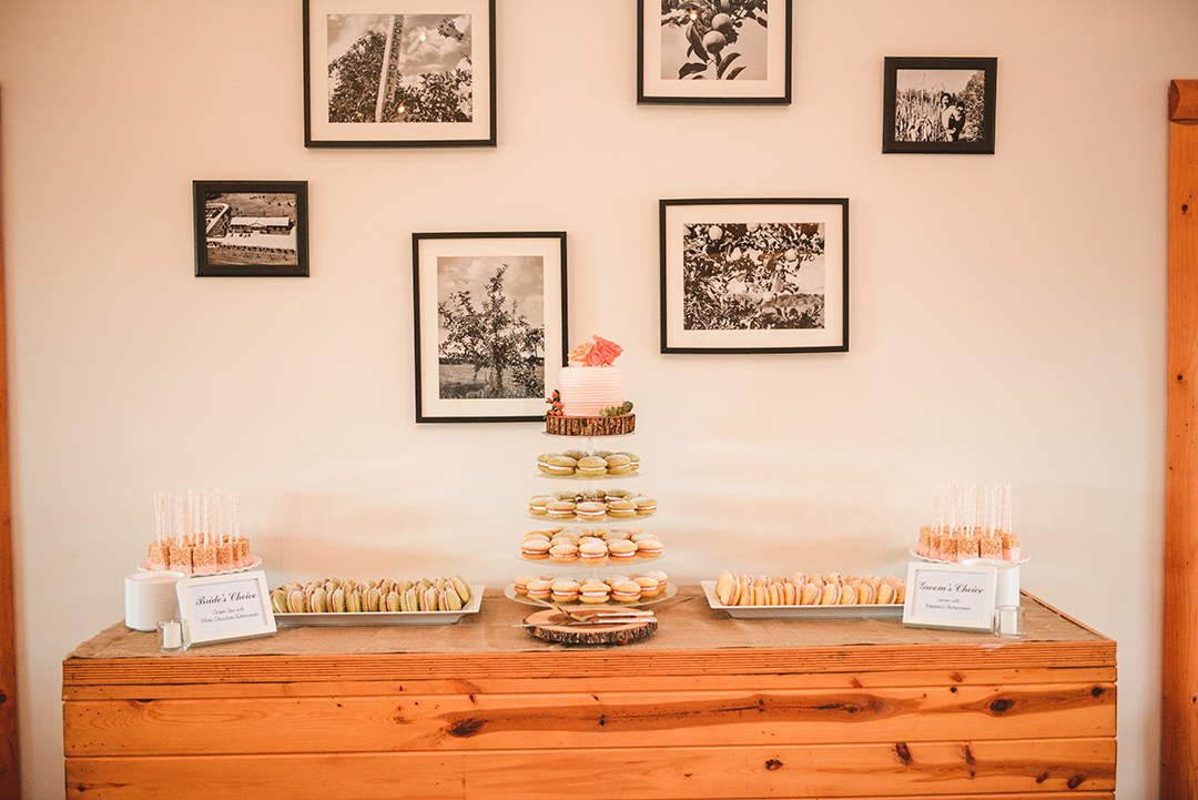 the sweets table at a wedding reception with pictures of apples and farms hanging on the wall