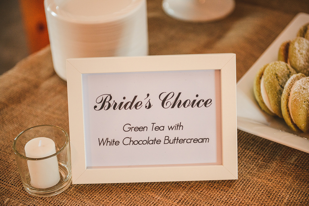 a sign with bride's choice green tea with white chocolate buttercream written on it at a sweets table