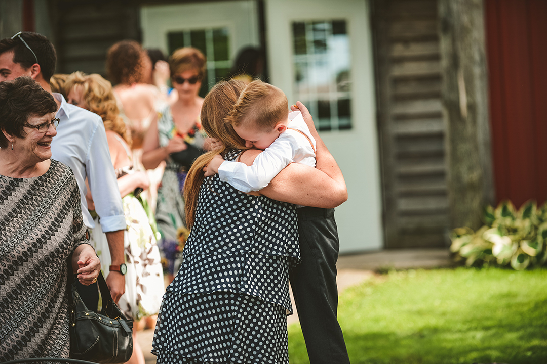 a little boy hugging his mother at a wedding ceremony at the All Season Orchard in Woodstock IL