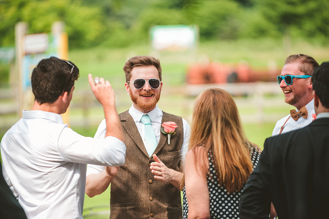 a groom laughing with his friends as they talk before his wedding