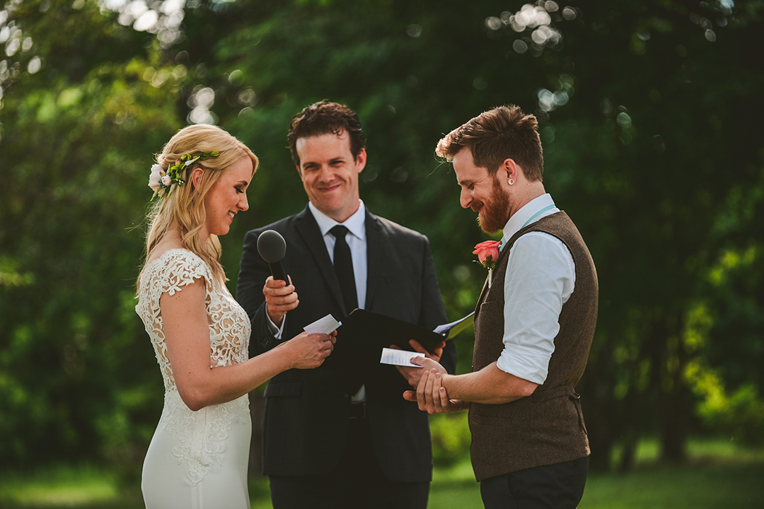 a husband and wife reading their vows to each other as they laugh at the All Season Orchard in Woodstock IL