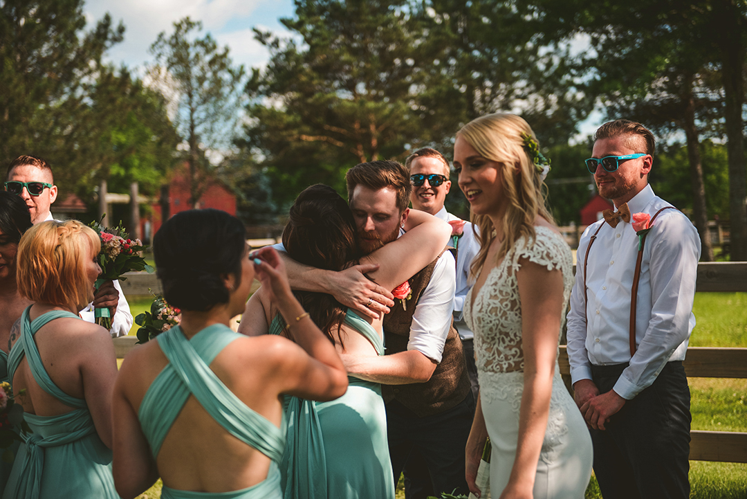 the groom hugging the maid of honor after he just got married at the All Season Orchard in Woodstock