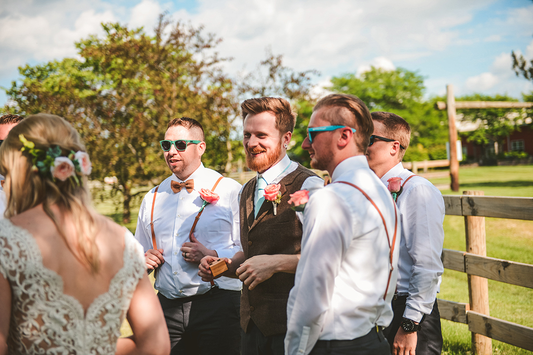 the groom laughing with his groomsmen after being married at the All Season Orchard