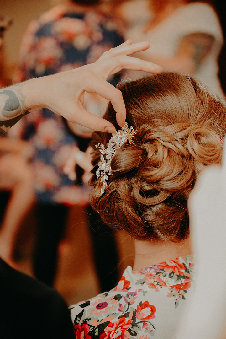 a hair stylist putting in a hair clip on the brides wedding day