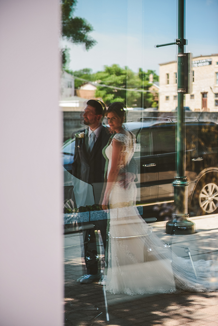 a reflection of a bride and groom with their arms around each other