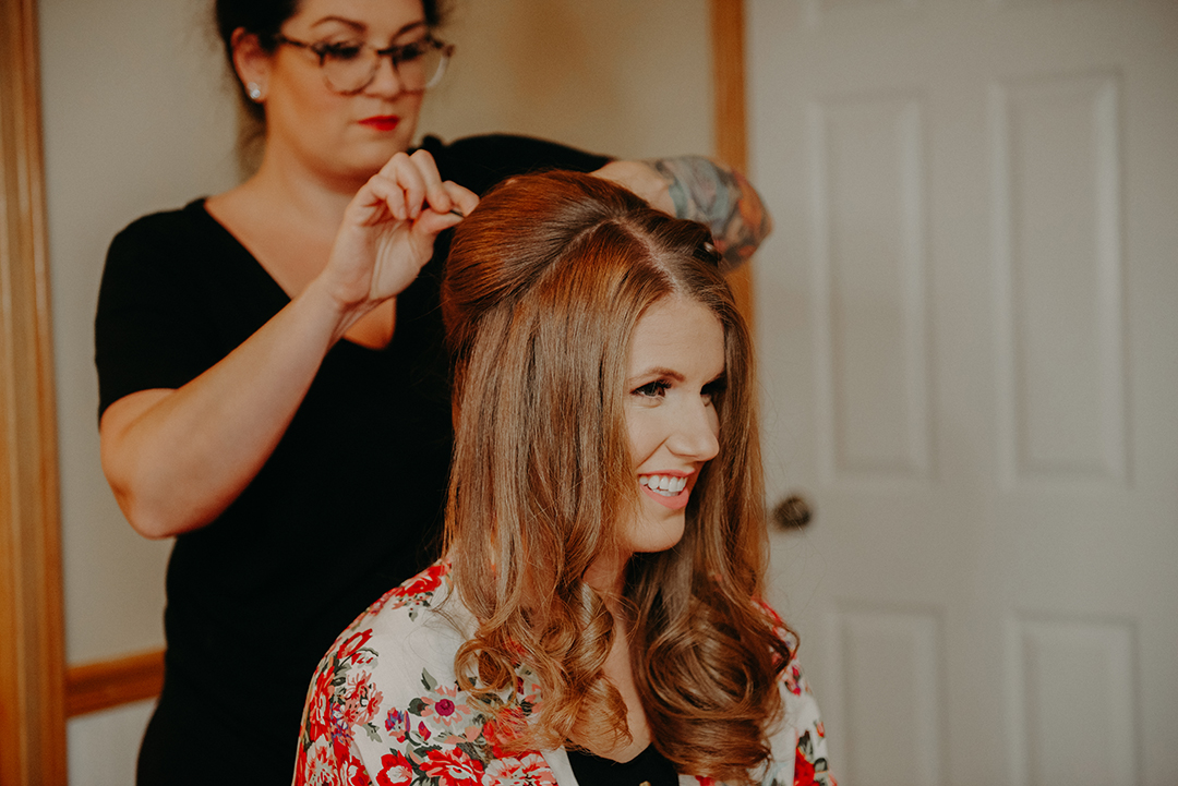 a hair stylist doing the brides hair