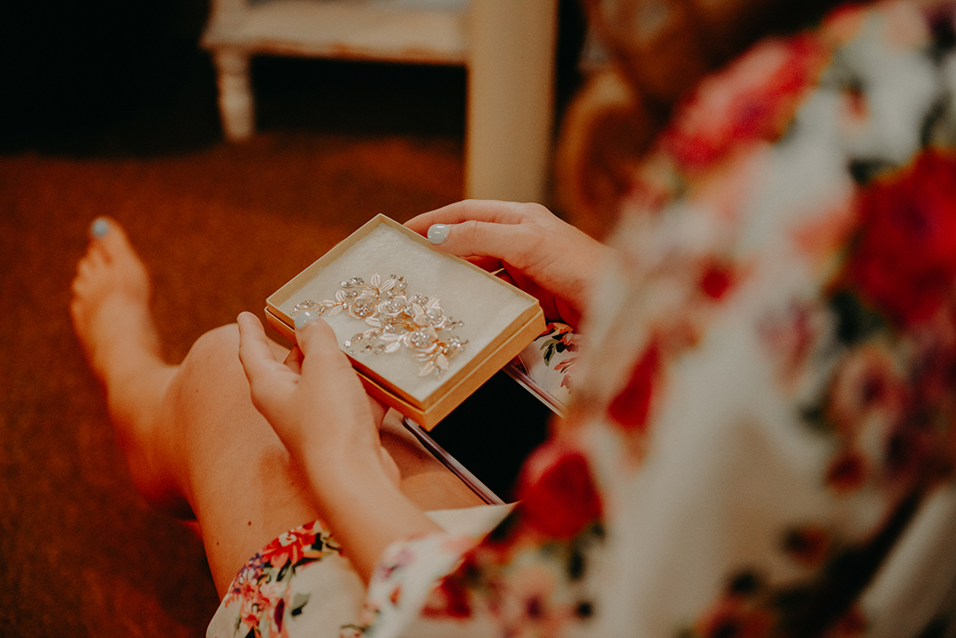 the bride holding onto a box with the clip she is going to put into her hair