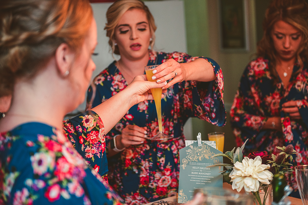 a bridesmaid handing out mimosas on the wedding day morning