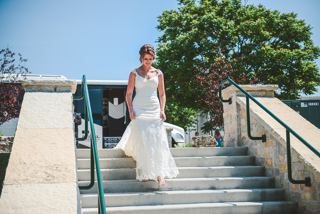 the bride walking down steps with her party bus in the background