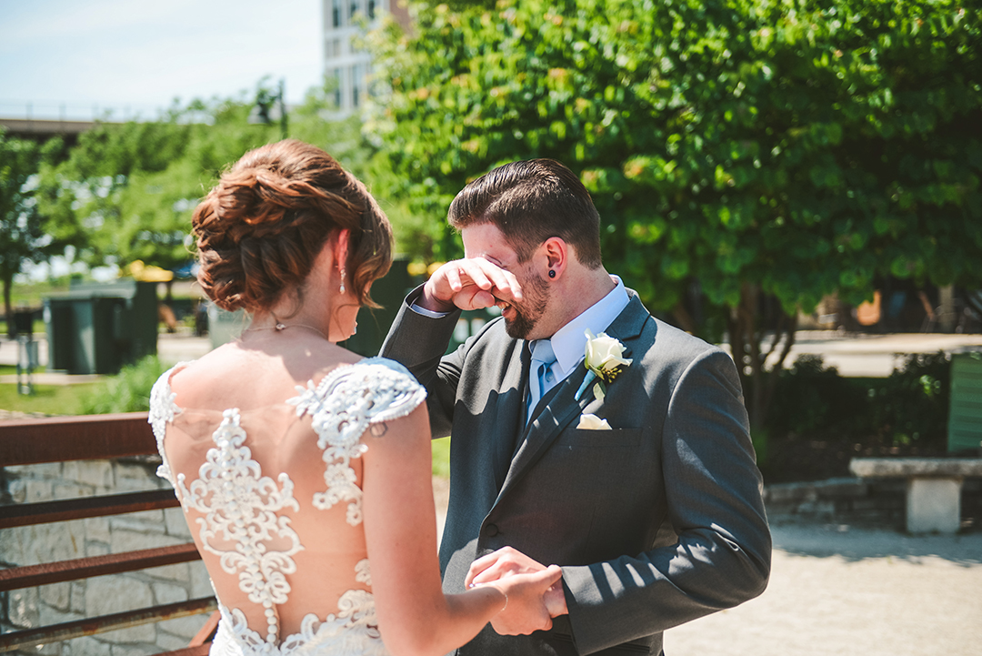 a groom brushing a tear away as he sees his bride for the first time