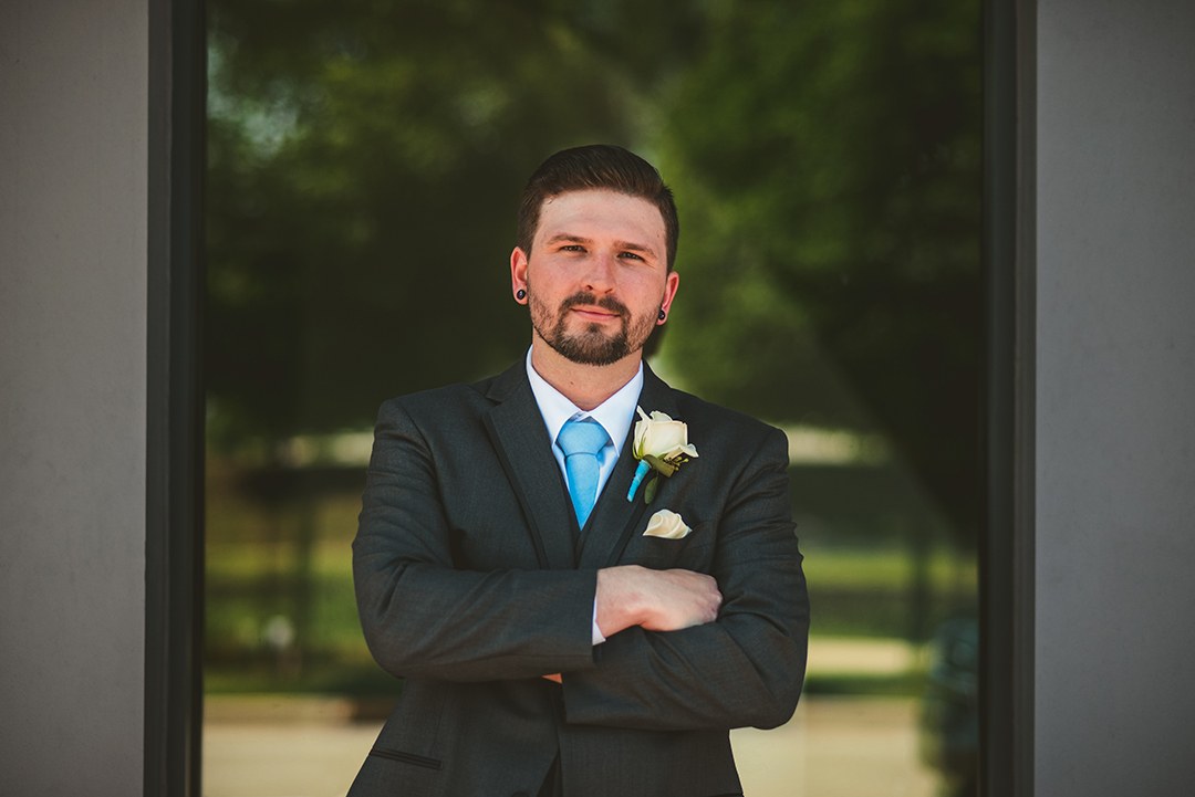 the groom standing with his arms crossed looking serious in Lemont