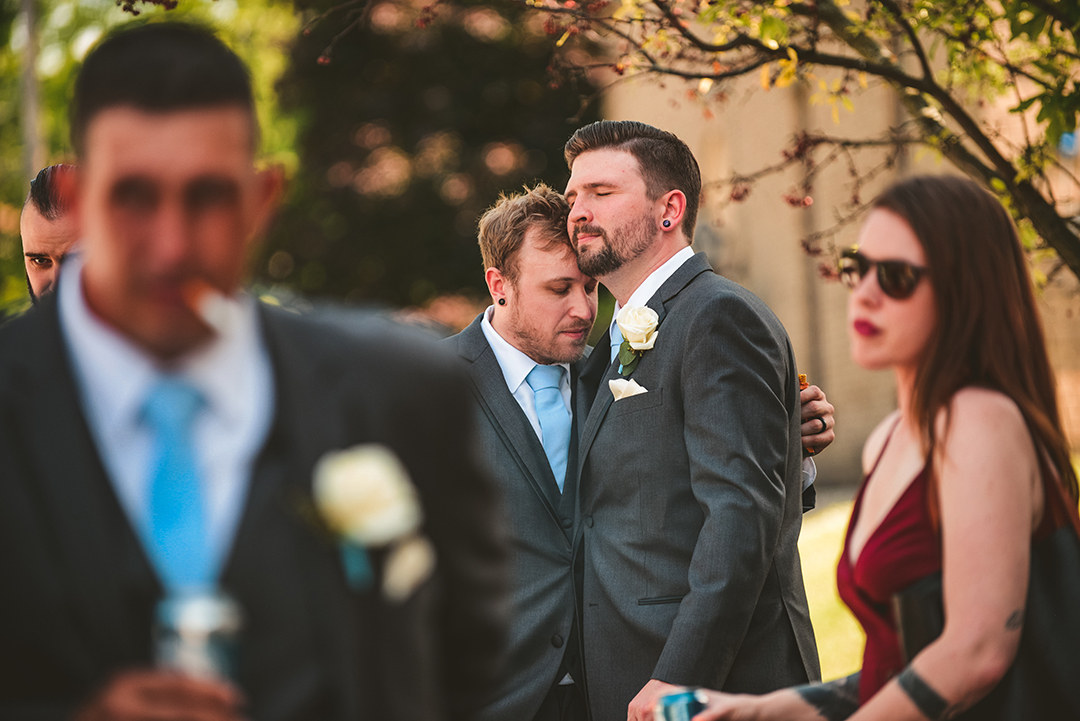 a groomsman hugging the groom before the wedding