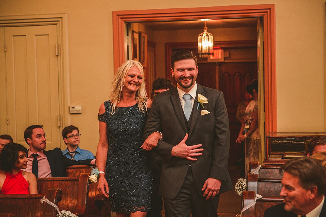 the groom walking his mother down the aisle at The Old Stone Church in Lockport