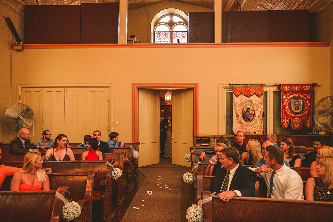 doors opening to show the bride and her father ready to walk down the aisle during her wedding