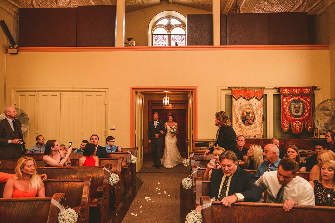 The bride and her father walking down the aisle as the doors open