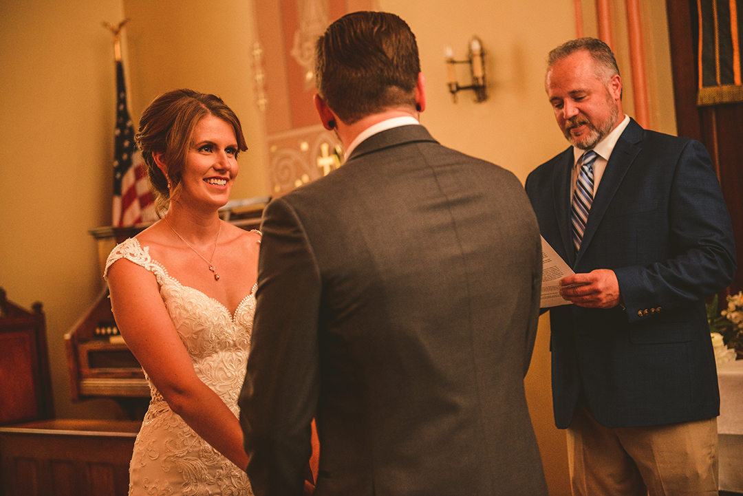 over the shoulder of a bride looking at her groom during their wedding ceremony