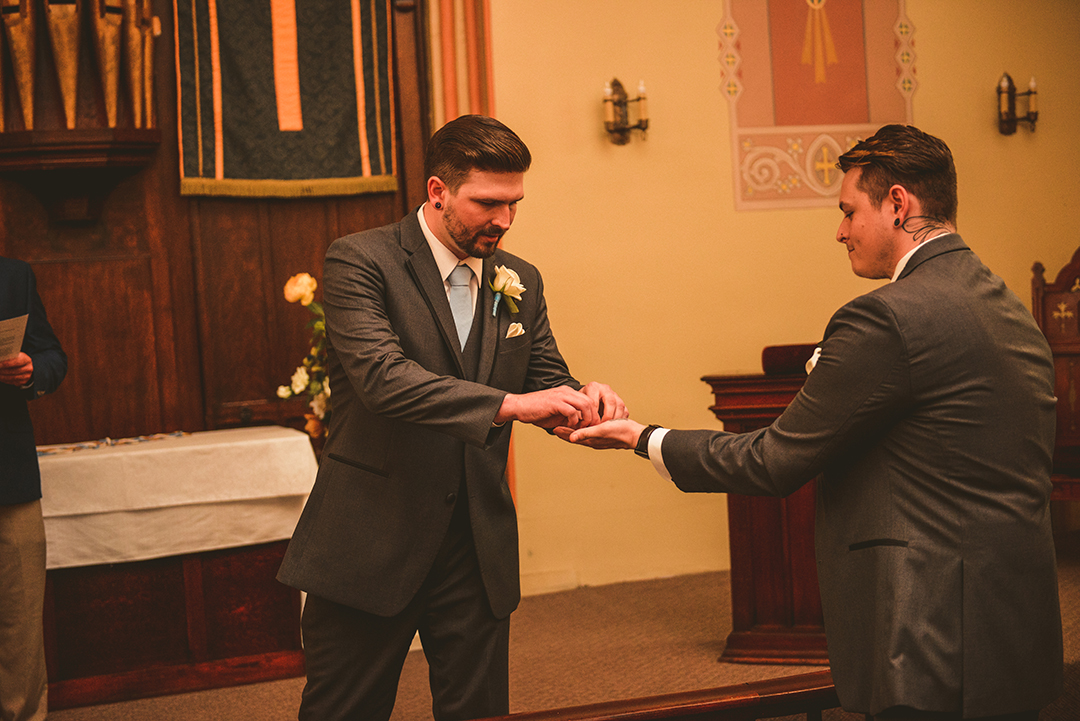 the groom taking the wedding rings from the best man during his wedding ceremony