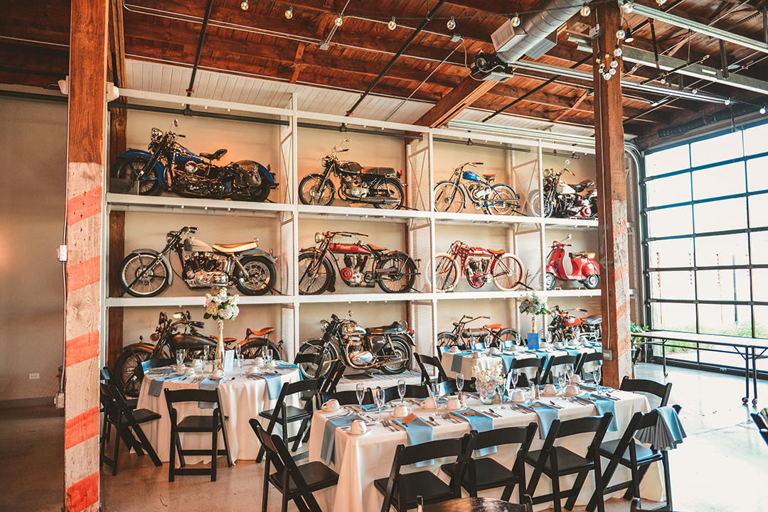 tables at a wedding reception in front of a wall of motorcycles at Warehouse 109 in Plainfield