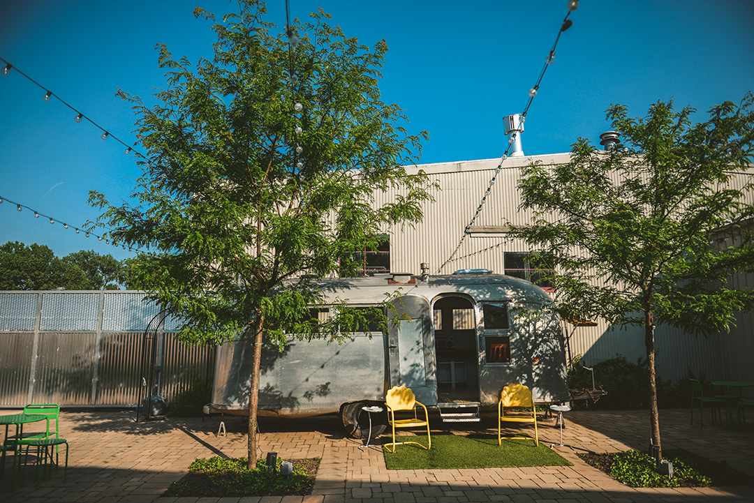 a camper in the patio of Warehouse 109 in Plainfield with a beautiful blue sky