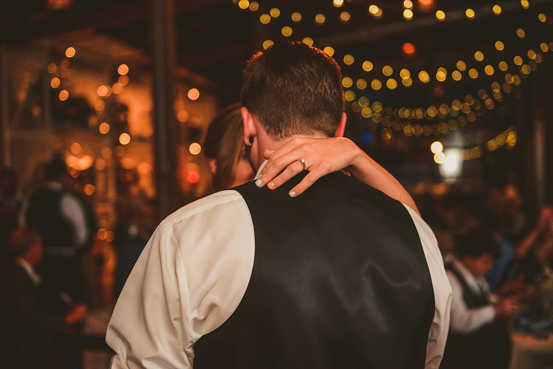 a brides hand on her grooms neck as they dance during their first dance