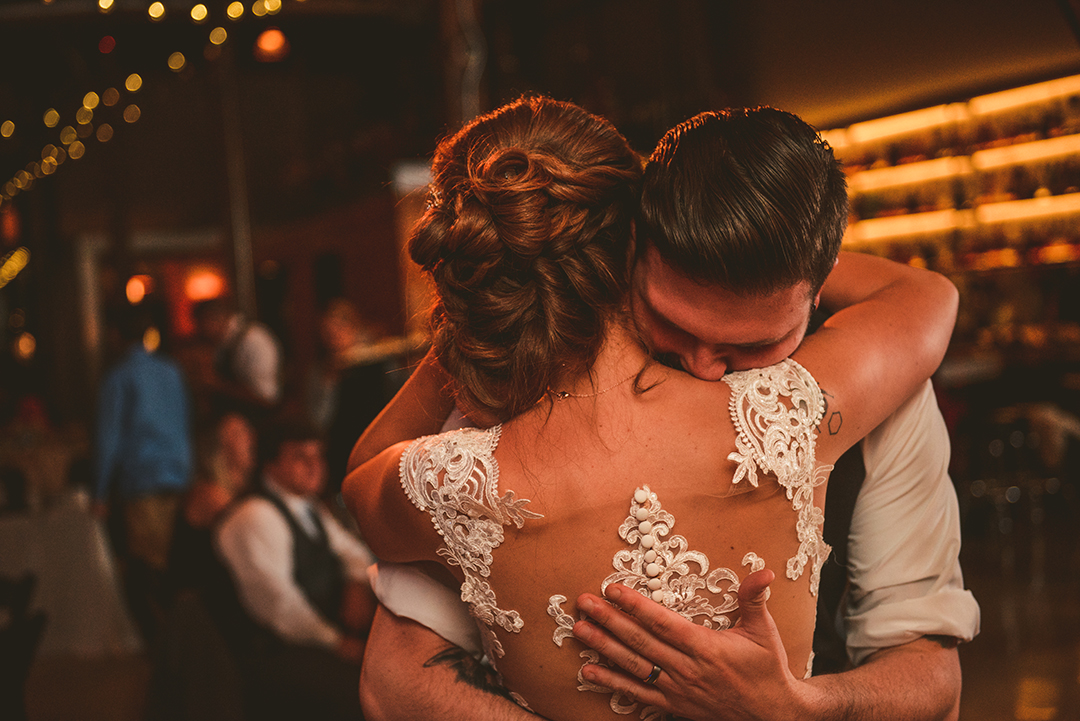 a groom hugging his bride during their first dance at Warehouse 109