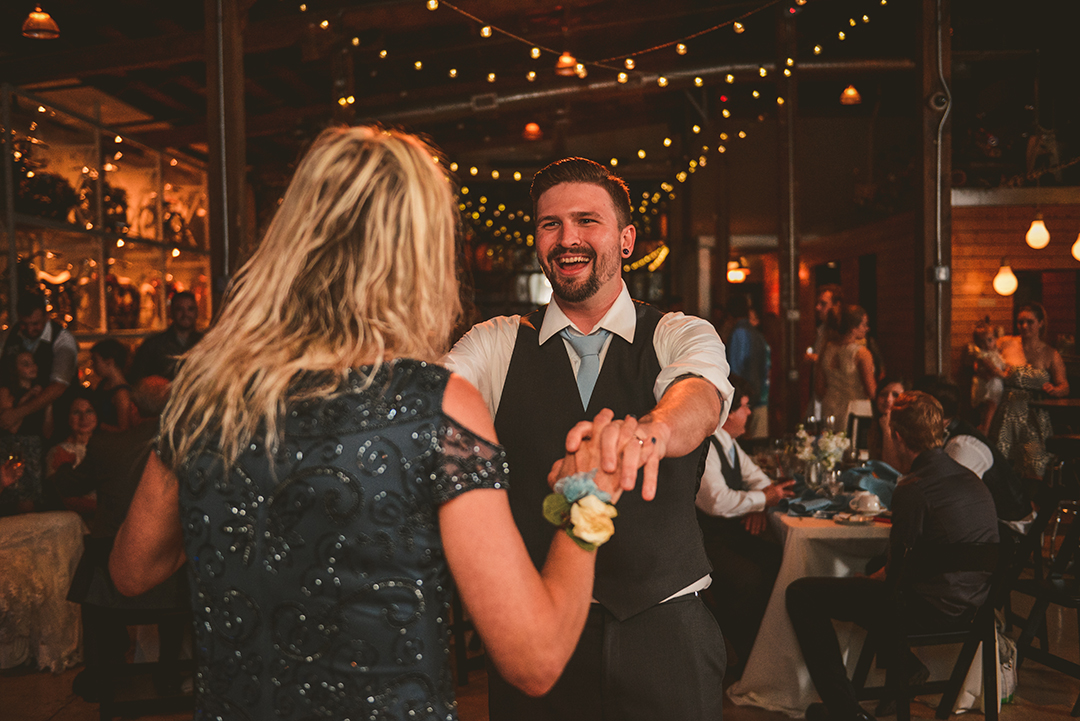 the groom laughing as he spins his mom on the dance floor at Warehouse 109