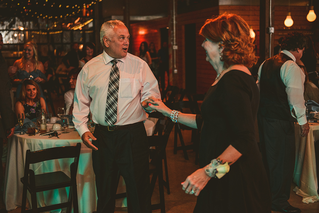 a man and a woman dancing at a wedding reception in a rustic wedding venue